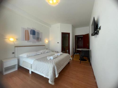 a bedroom with a white bed and a desk at Apartmani Baki in Podstrana