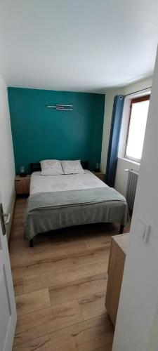 une chambre avec un lit et un mur bleu dans l'établissement Le clos des primevères, à Aix-les-Bains