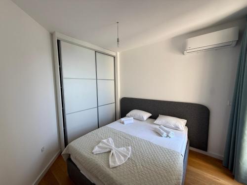 a bedroom with a bed with a bow on it at Lux Apartman Rafailovici in Rafailovici