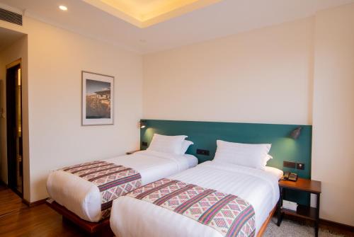 two beds in a hotel room with at Bhutan Peaceful Residency and Spa in Thimphu