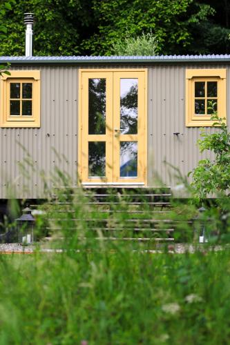 a small shed with a yellow door and windows at Tiny House at Villa Ariola in Irola