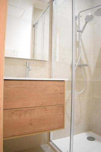 une salle de bain avec une douche avec un lavabo et un miroir dans l'établissement Villa de charme en pierre, à San-Martino-di-Lota