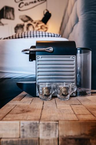 a toaster and two glasses on a wooden table at Penzion Na Červeném Potoce in Králíky