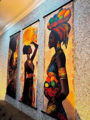 a group of three paintings on a wall at White House In Borjomi in Borjomi