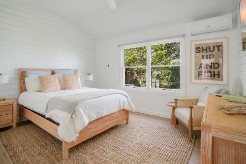 a white bedroom with a bed and a window at Dockside 2BR - Marina - Dining - Charter Access Unit A in Montauk