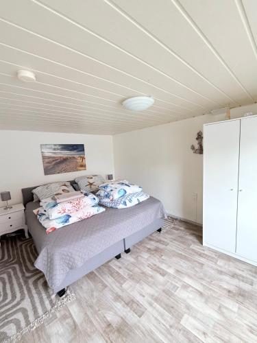 a bedroom with a bed in a white room at Ferienhaus mit Wasserblick auf der Insel Usedom in Krummin