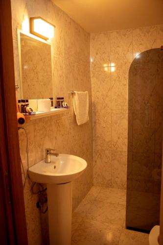a bathroom with a sink and a shower at THE SANDHİLl OTEL RESTAURANT in Kemer