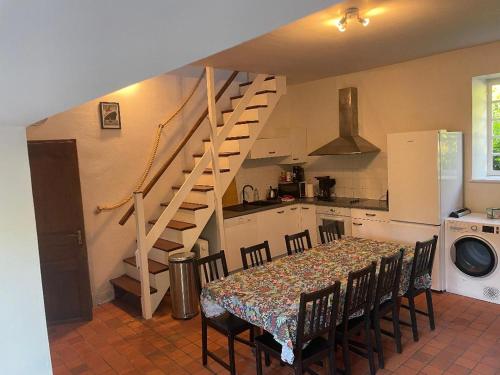 une cuisine avec une table et des chaises ainsi qu'un escalier dans l'établissement Self Catering GIte des trauchandieres, à Saint-Jouan-des-Guérets
