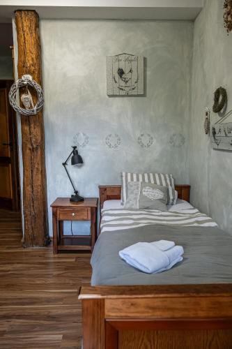 a bedroom with a bed and a table with a lamp at Penzion Na Červeném Potoce in Králíky