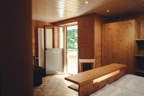 a room with a bed and a wooden wall at Pension Rudolph in Gaschurn