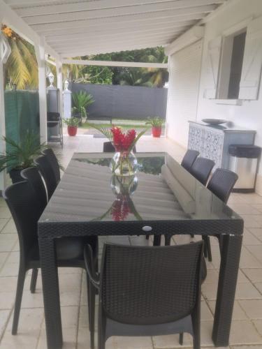 a dining table and chairs on a patio at Villa Lawrencia in Morne-à-lʼEau