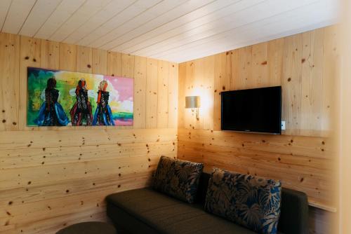 a living room with a couch and a flat screen tv at Pension Rudolph in Gaschurn