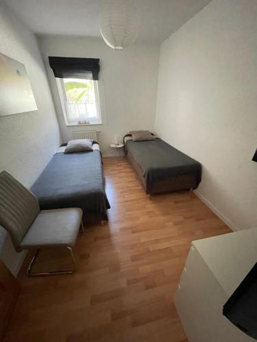 a room with two beds and a chair and a window at Ferienwohnung Happy in Tangermünde