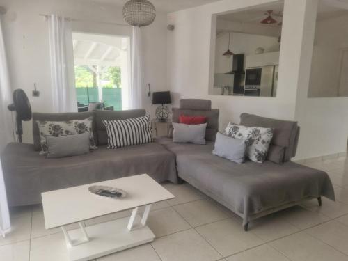 a living room with a couch and a table at Villa Lawrencia in Morne-à-lʼEau