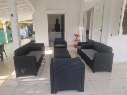 a living room with couches and chairs in a building at Villa Lawrencia in Morne-à-lʼEau