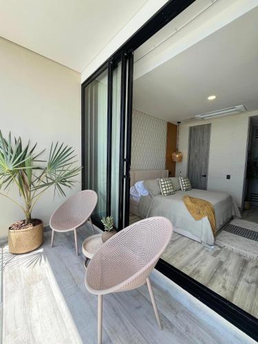 a bedroom with a bed and two chairs at Almare Apartamentos nuevos in Gustavo Rojas Pinilla International
