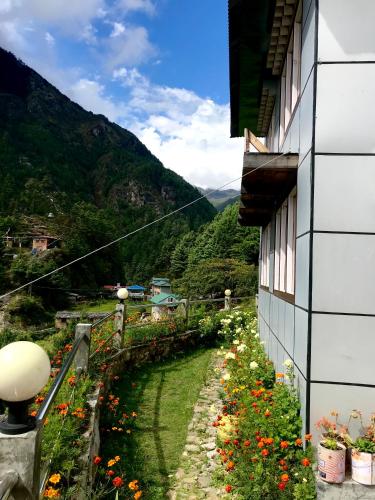 a building with flowers on the side of it at Buddha Lodge and Restaurant, Monjo in Khumjung