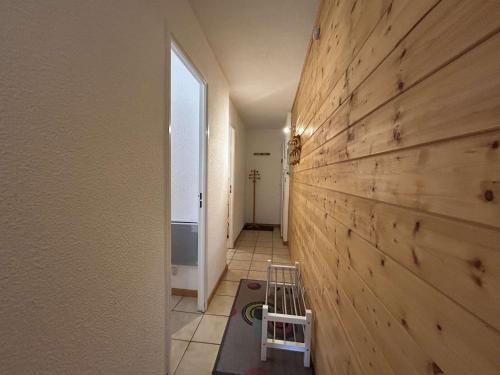 un couloir avec un mur lambrissé de bois et un petit tabouret dans l'établissement Appartement cosy 4/5 pers, centre Montgenèvre - FR-1-330D-72, à Montgenèvre
