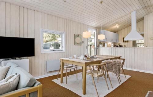 a dining room with a table and a couch at 3 Bedroom Stunning Home In Blokhus in Blokhus