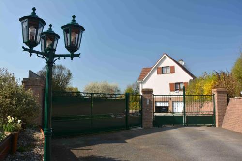 a street light with a gate in front of a house at L'Horizon de la Côte d'Opale in Hesdin-lʼAbbé