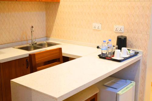 eine Küche mit einer Arbeitsplatte mit einer Spüle und einer Theke von sidx sidx sidx in der Unterkunft Urban Park Suites Hotel in Kigali