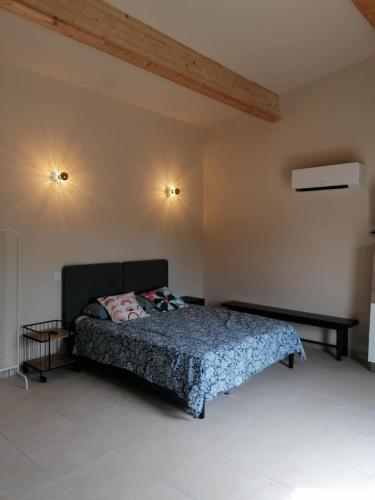 a bedroom with a bed and two lights on the wall at Gite Studio dans village au calme in Crespian