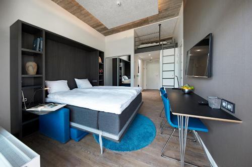 a bedroom with a bed and a desk and a bed and a table at Living Suites in Nærum