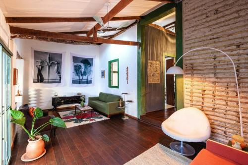 a living room with a green couch and a brick wall at Incrível Casa Colonial-Déco - Centro Histórico in Marechal Floriano