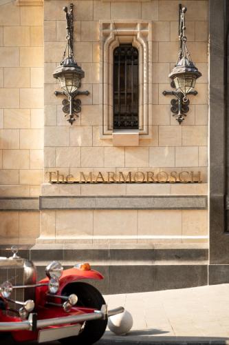 a red scooter parked in front of a building at The Marmorosch Bucharest, Autograph Collection in Bucharest