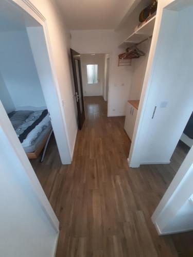 a hallway of a room with a bed and wooden floors at Erdgeschoss 75 m2 Großer Parkplatz WLAN Terrasse 30 m2 Übernachtung Unterkunft in Talheim