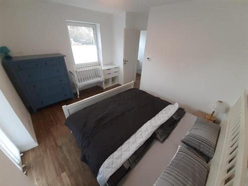 a bedroom with a bed and a blue dresser and a window at Erdgeschoss 75 m2 Großer Parkplatz WLAN Terrasse 30 m2 Übernachtung Unterkunft in Talheim