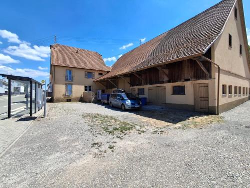 a barn with a car parked next to a building at Erdgeschoss 75 m2 Großer Parkplatz WLAN Terrasse 30 m2 Übernachtung Unterkunft in Talheim