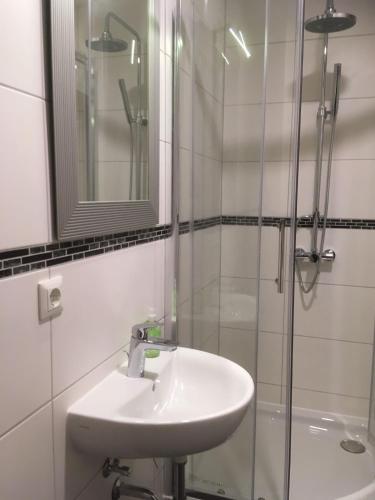 ein weißes Badezimmer mit Waschbecken und Dusche in der Unterkunft Hotel M68 in Berlin