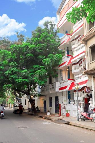 a tree on the side of a street next to a building at Le Clarisse Guest House in Puducherry