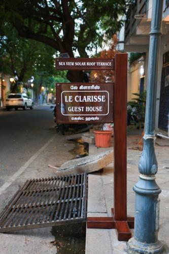 a sign for a us chinese guest house on a street at Le Clarisse Guest House in Puducherry