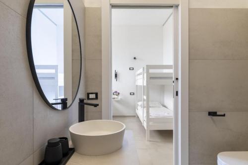 a bathroom with a white tub and a mirror at EnSe Affittacamere in Tortolì