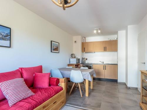 un salon avec un canapé rouge et une cuisine dans l'établissement Appartement 2 pièces avec balcon et garage à 100m des pistes - FR-1-351-215, à La Plagne Tarentaise