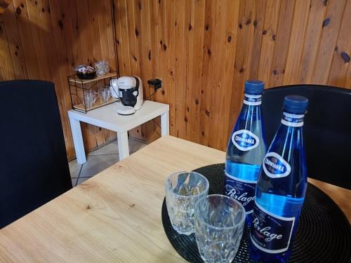 twee flessen water op een tafel met glazen bij Dom Letniskowy in Wielen Zaobrzanski