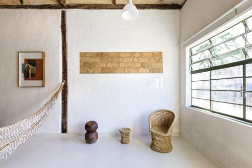 a room with a rattan chair and a window at Incrível Casa Colonial-Déco - Centro Histórico in Marechal Floriano