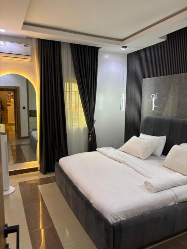 une chambre avec un grand lit dans une pièce dans l'établissement Peridot Lush Apartment Wuye, Utako Abuja, à Abuja