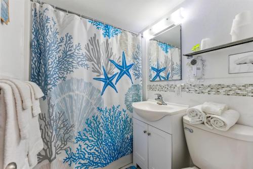 Un baño con cortina de ducha y lavabo. en 6201 Ocean Ave, Unit 406 - The Nassau Inn, en Wildwood