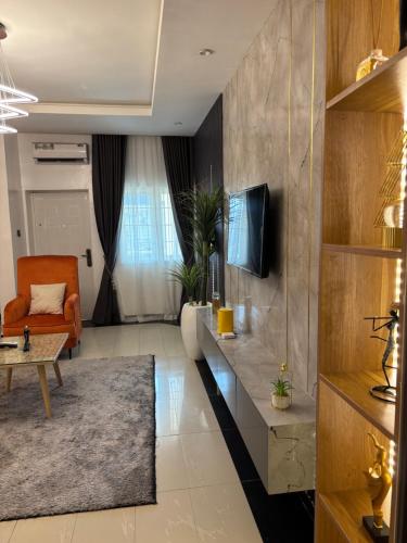 un salon avec un canapé et une télévision dans l'établissement Peridot Lush Apartment Wuye, Utako Abuja, à Abuja
