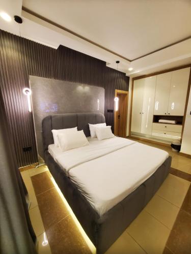 une chambre avec un grand lit blanc dans une pièce dans l'établissement Peridot Lush Apartment Wuye, Utako Abuja, à Abuja