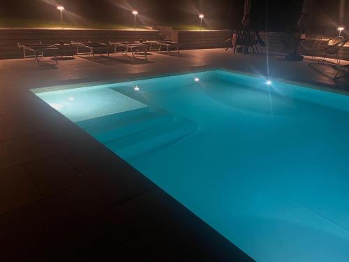 a swimming pool lit up at night at Bed & Breakfast L'Albero Maestro in Borgofranco dʼIvrea