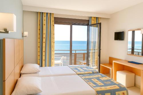 a hotel room with a bed and a balcony at Flisvos Hotel in Tolo