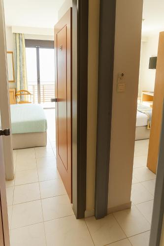 a hallway with a room with a bed and a door at Flisvos Hotel in Tolo