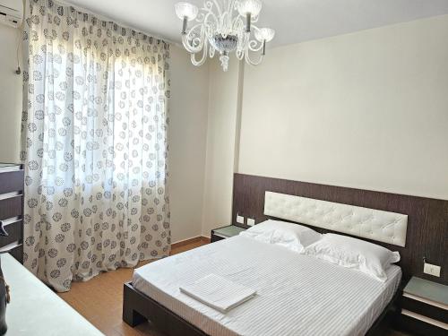 a bedroom with a bed and a chandelier at Casa sul Mare in Vlorë