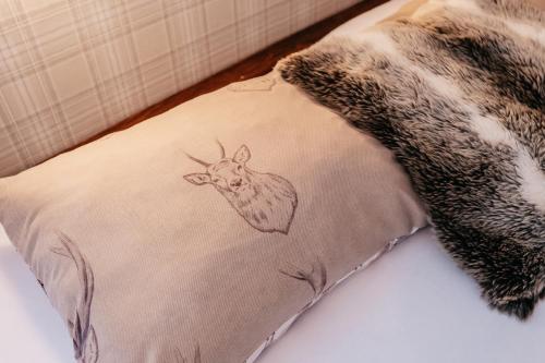 a pillow with a drawing of a deer on it at Penzion Na Červeném Potoce in Králíky