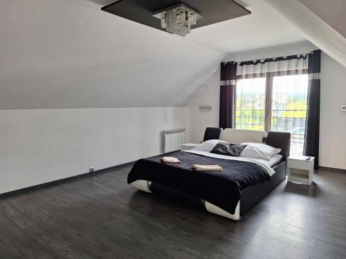 a bedroom with a large bed with a black blanket at Apartament Perła Pienin in Dębno