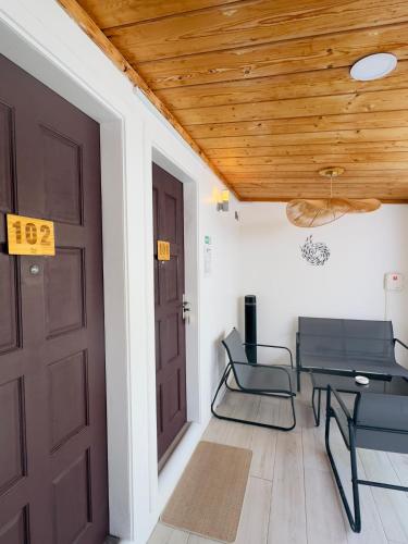 Habitación con puerta, sillas y mesa. en Avi Cabana, en Himmafushi